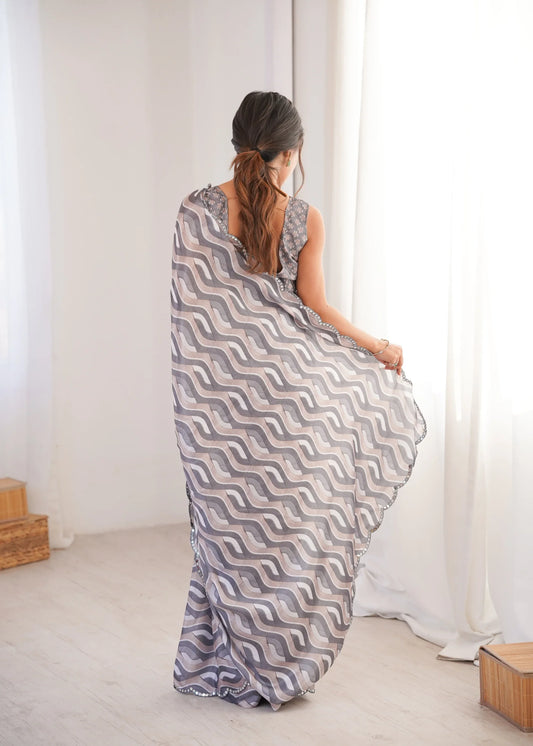 Woman wearing a long, patterned dress in a minimalistic room Glanzavi.
