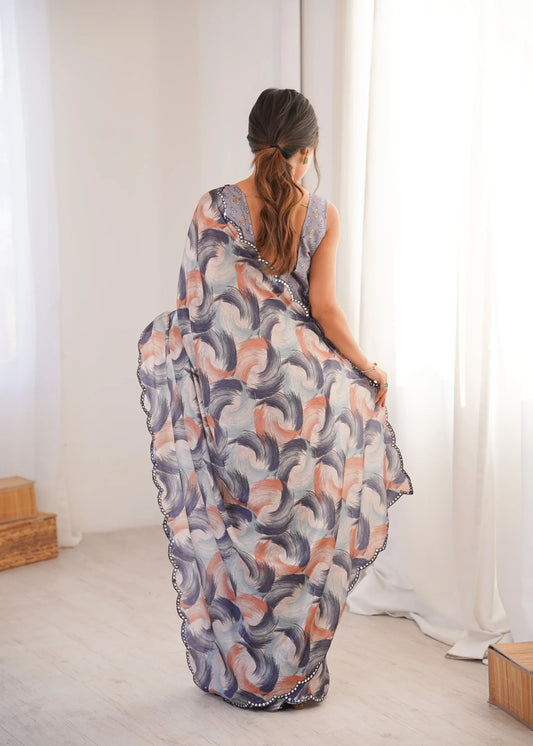 Woman wearing a patterned dress standing in a bright room with white curtains Glanzavi.