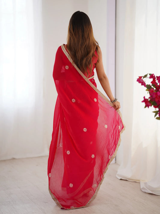 Woman wearing a red saree with white patterns in a minimalistic setting Glanzavi