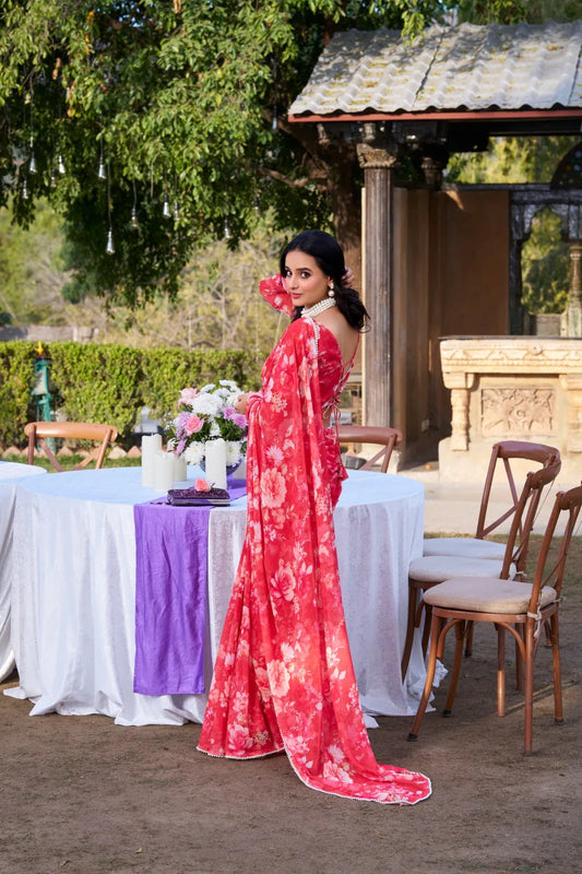 Woman in a red floral dress standing outdoors near a table with a purple runner Glanzavi.