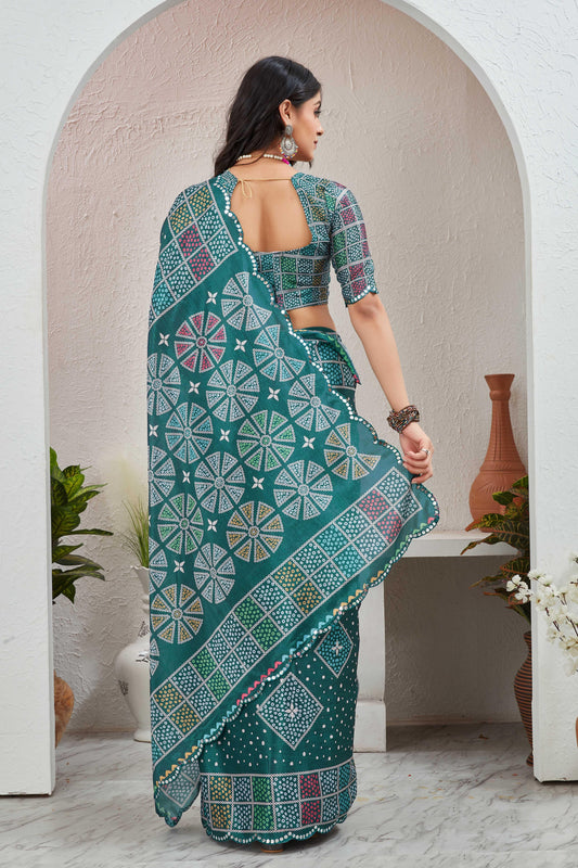 Woman wearing a green saree with a geometric pattern, standing in a room with white walls and a vase Glanzavi.