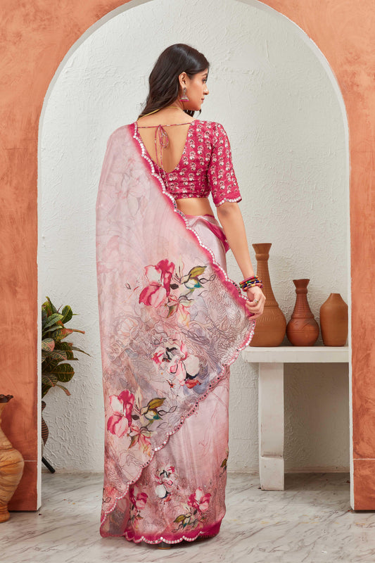 Woman in a pink floral saree standing in front of a decorative archway with vases Glanzavi