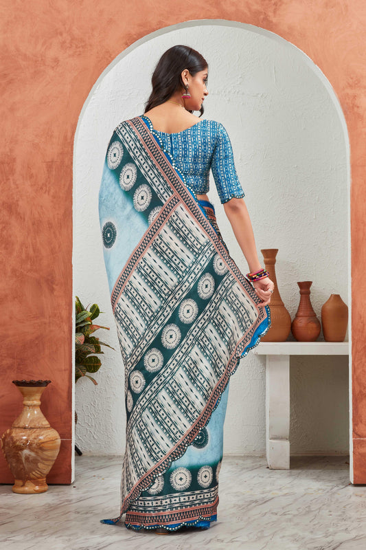 Woman wearing a traditional saree with a patterned design, standing in a room with decorative vases Glanzavi