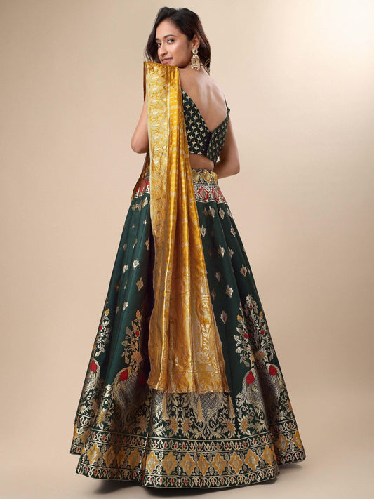 Woman wearing a traditional green and gold lehenga with a black blouse on a beige background Glanzavi