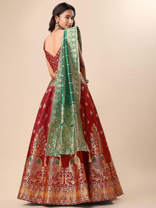 Red and gold embroidered traditional outfit with a green dupatta on a beige background Glanzavi