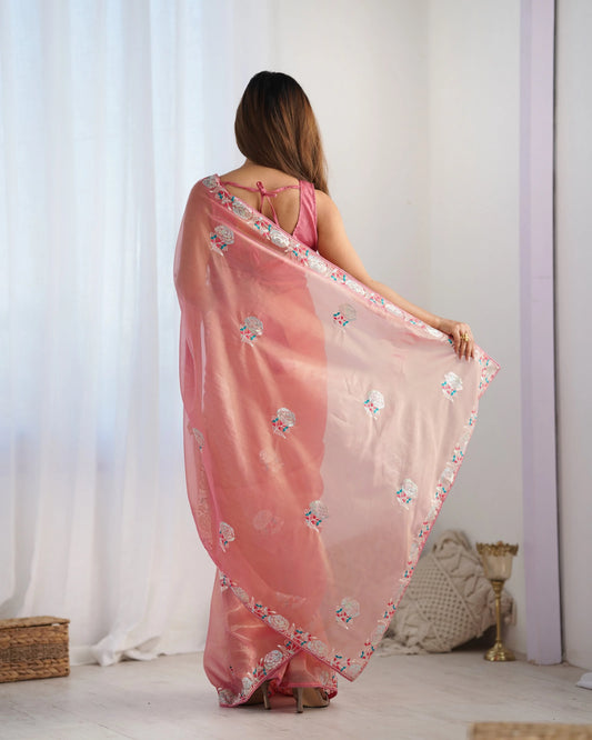 Woman wearing a Peach floral saree in a minimalistic setting Glanzavi