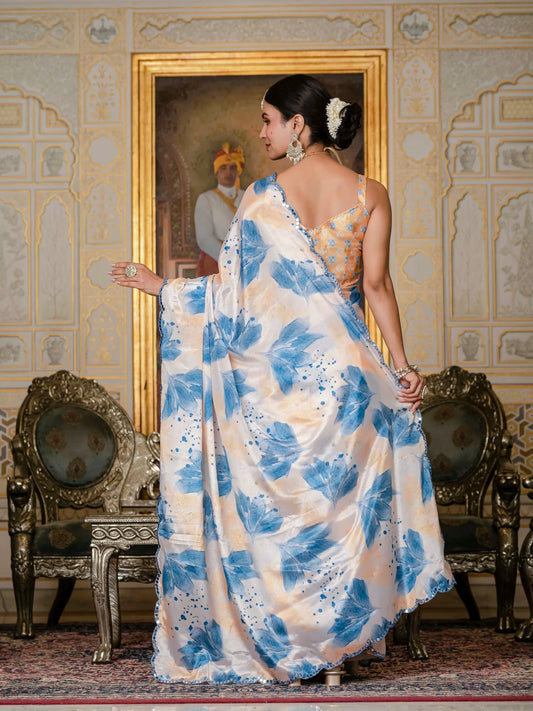 Woman in a blue and white floral saree standing in an ornate room with decorative chairs and wall art Glanzavi.