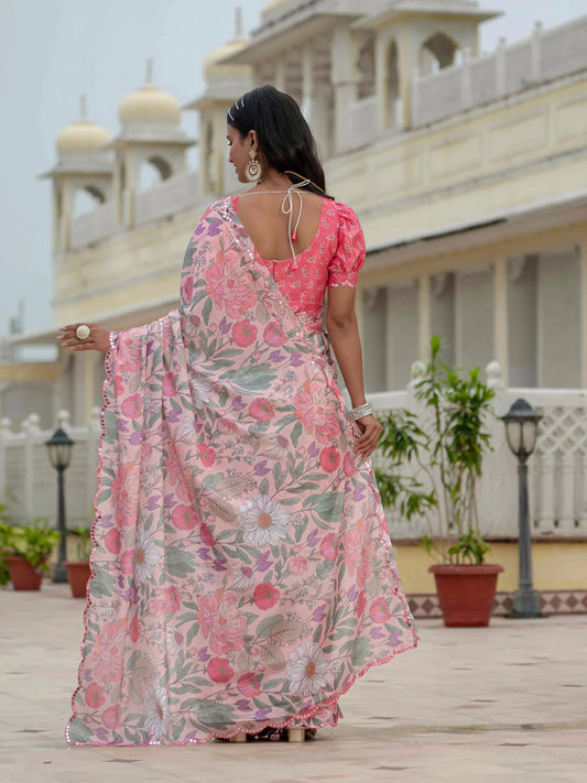 Woman in a floral saree standing in front of a building with domes Glanzavi.