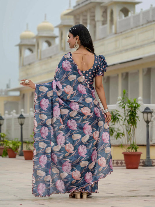 Woman in a floral saree standing in front of a building with domes Glanzavi.