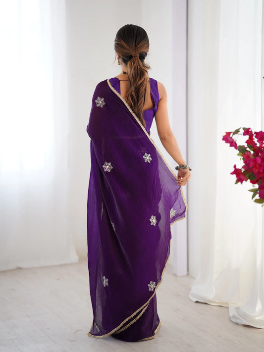 Woman wearing a purple saree with floral patterns in a minimalistic setting Glanzavi.