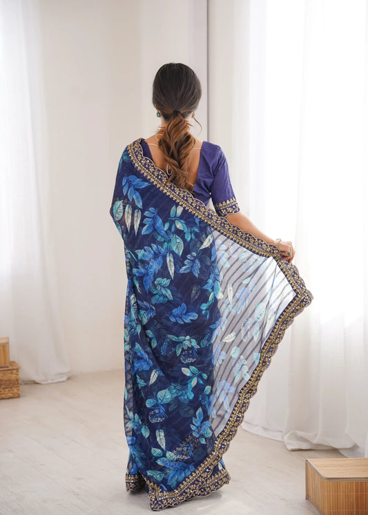 Woman wearing a blue floral saree with a white background Glanzavi