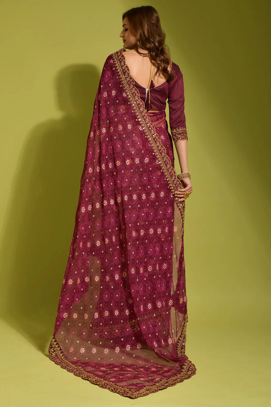Woman wearing a purple saree with gold patterns on a green background Glanzavi
