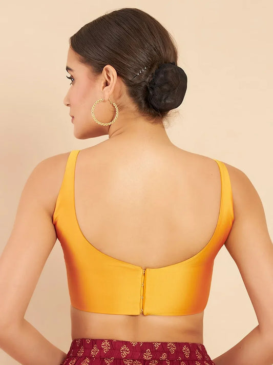 Woman wearing a yellow top with an open back on a beige background Glanzavi