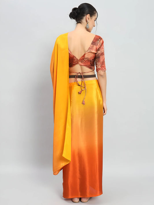 Woman wearing a yellow and orange saree with a red blouse on a light gray background Glanzavi